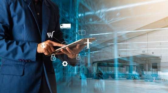 Logistics manager using a tablet to monitor warehouse and fleet data